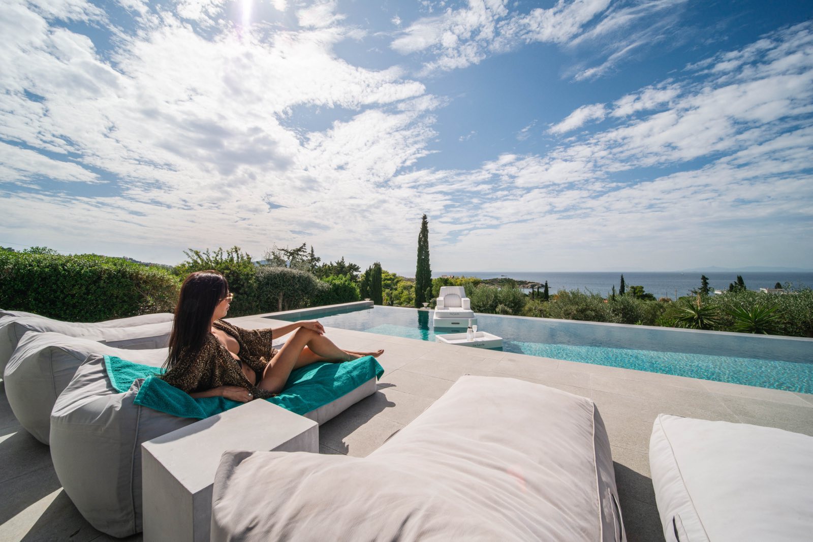 chica en sofa en piscina infinita
